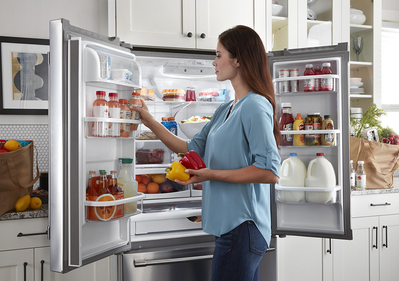 Female Putting Groceries in a Refrigerator